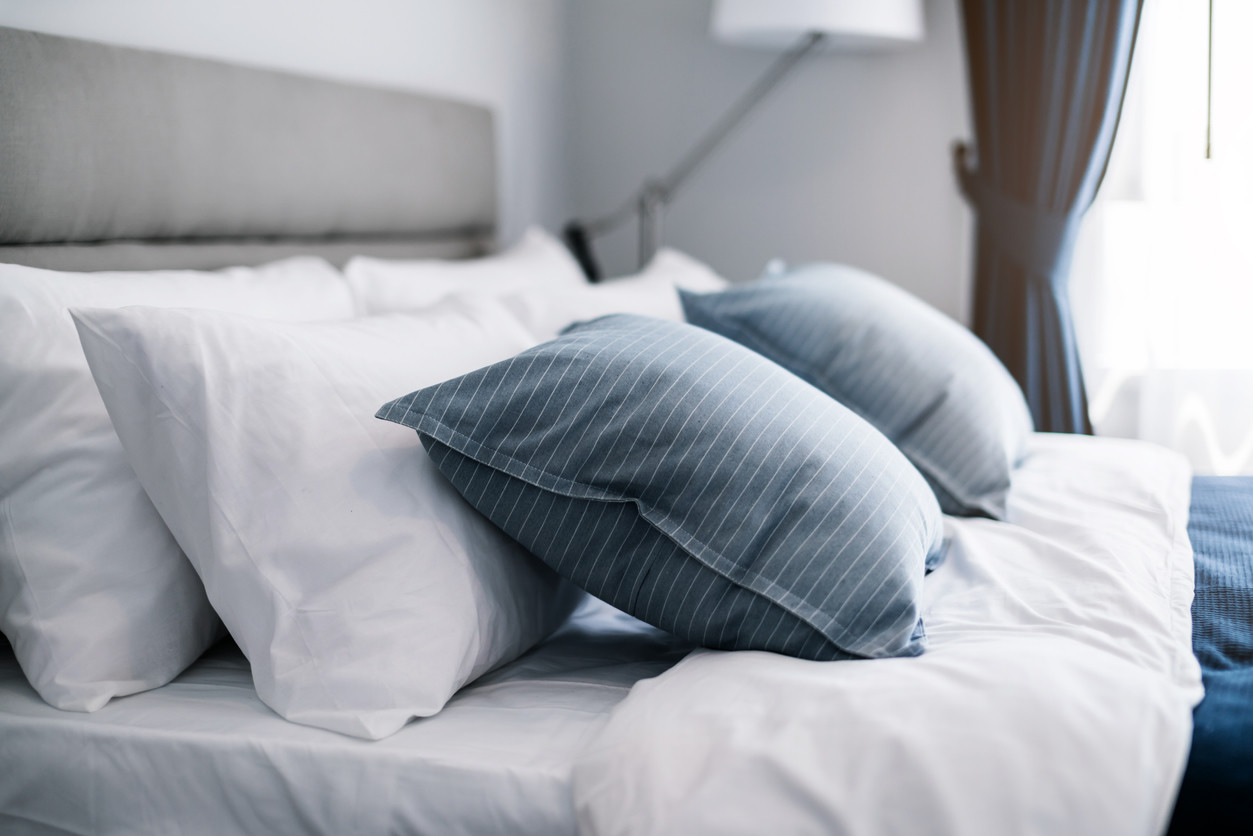 Blue and white pillows on a neatly made bed.