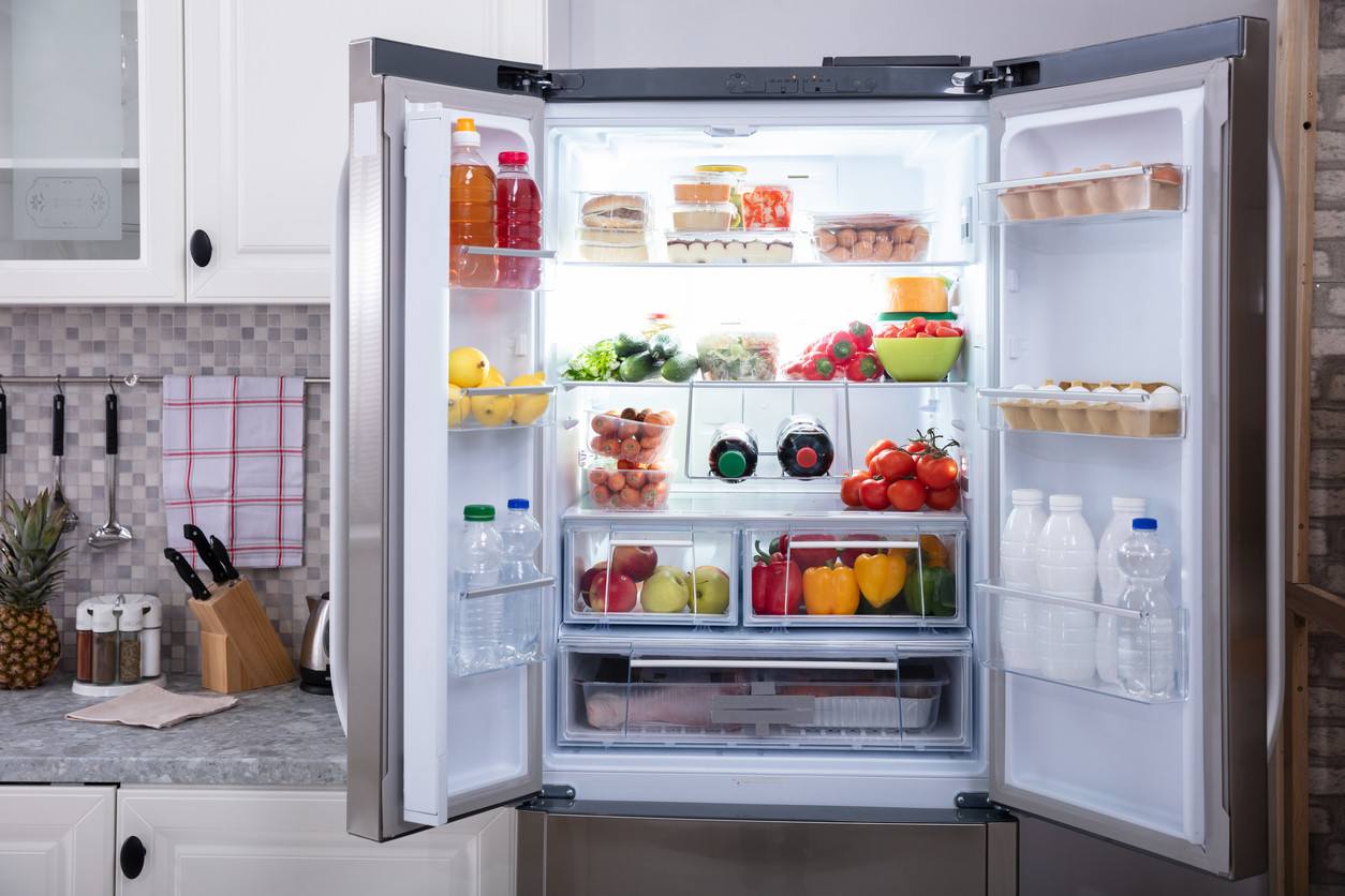 An open refrigerator with food on its shelves.